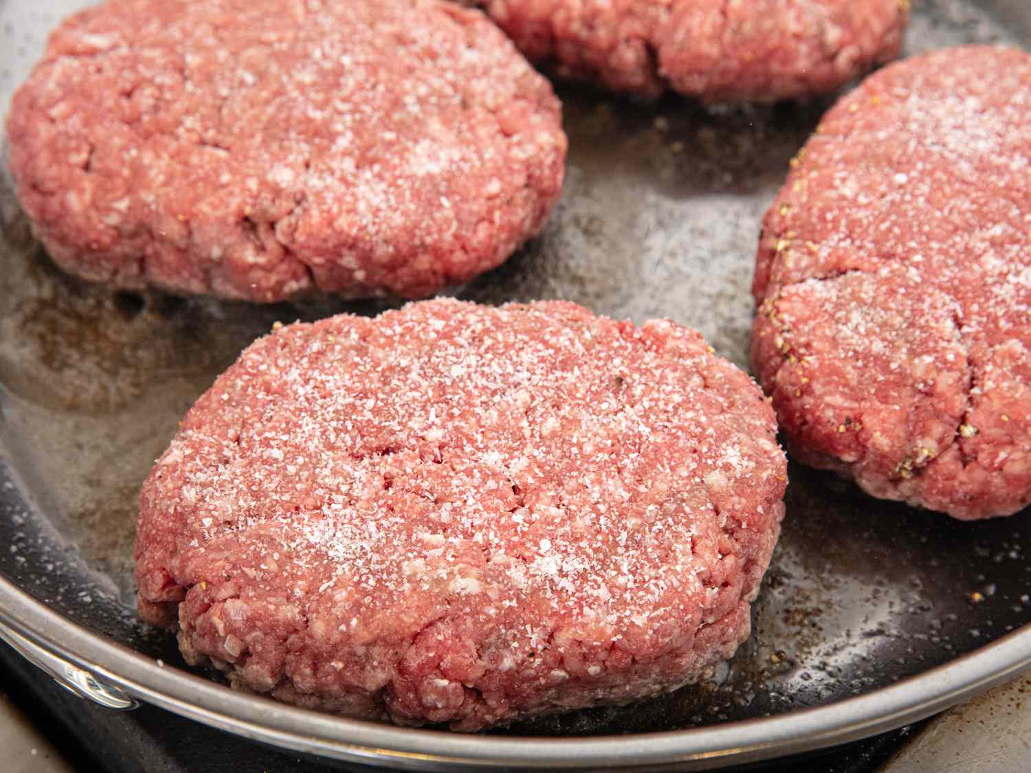 Seasoned patties on a skillet 