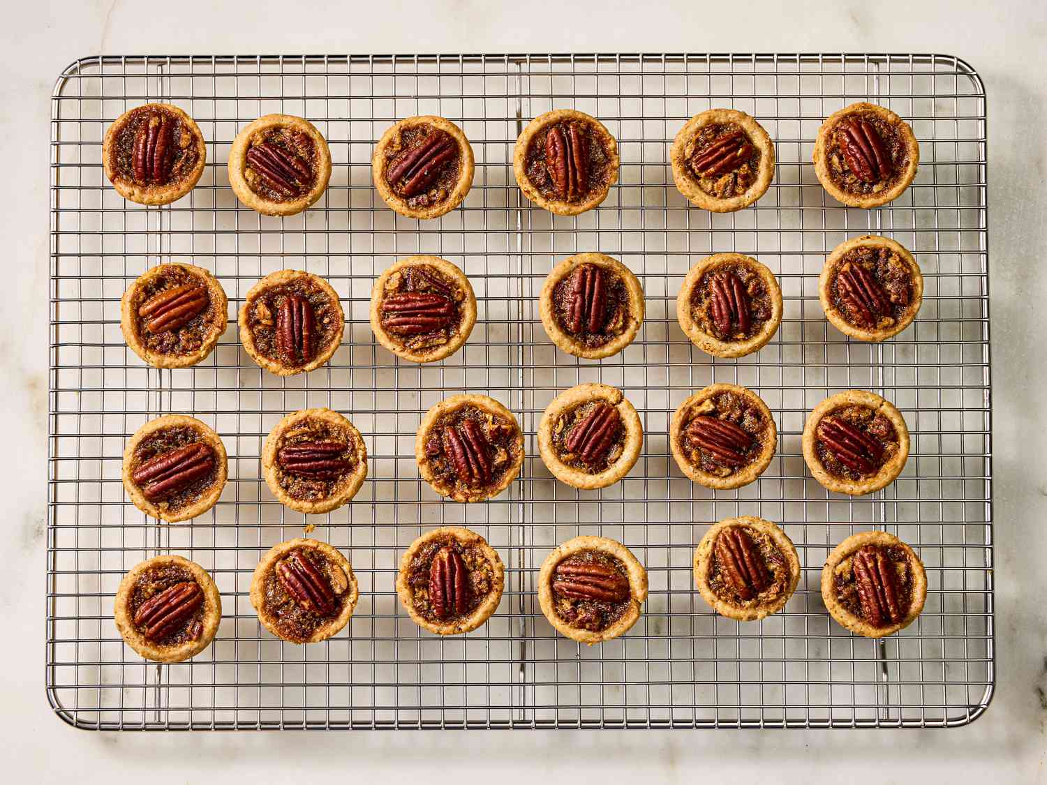 Baked pecan tassies on a cooling rack