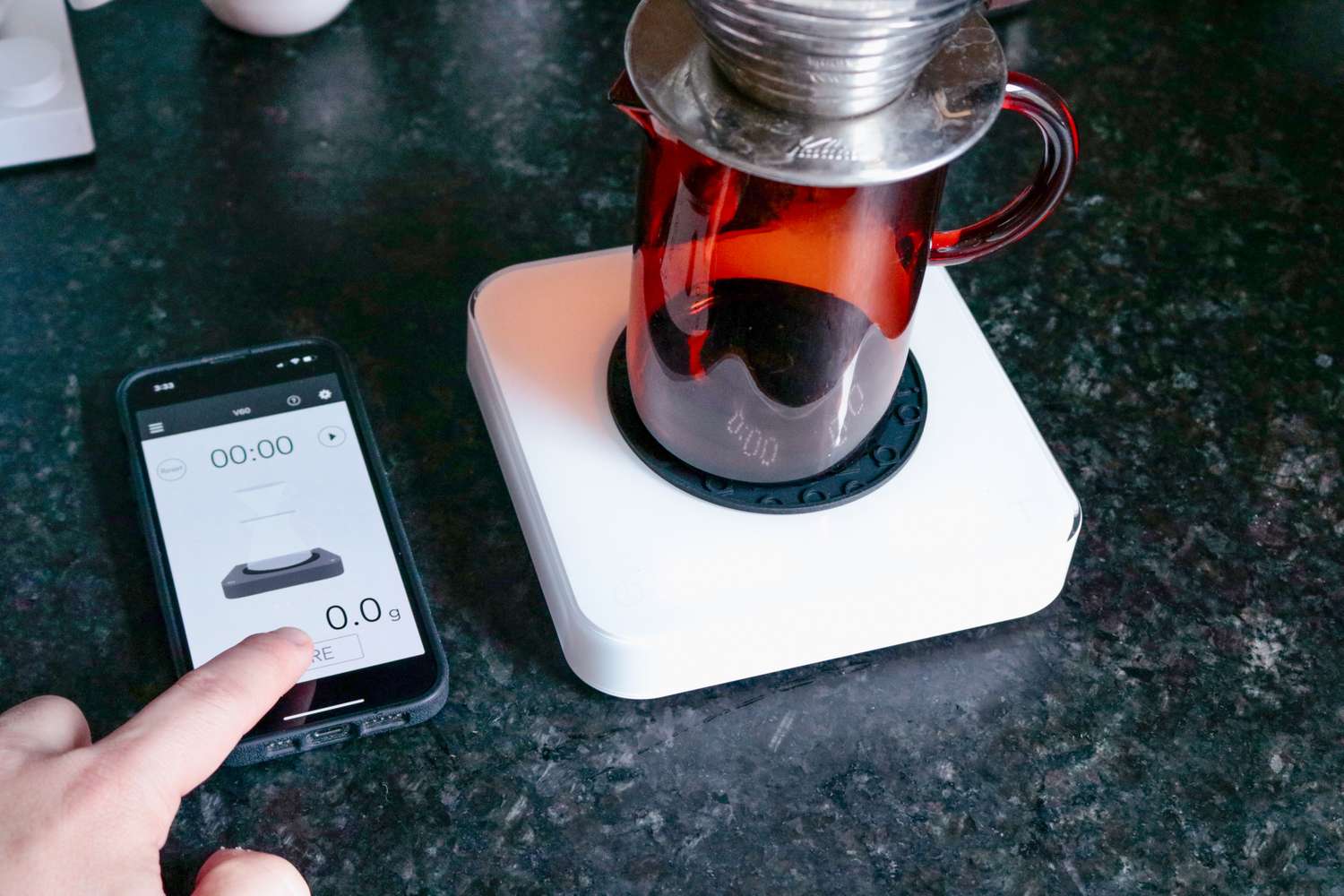 A scale system is used for coffee brewing with a smartphone app displaying measurements and interface