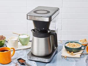 The OXO Brew 8-Cup Coffee Maker displayed on a kitchen counter with breakfast food and mug of coffee