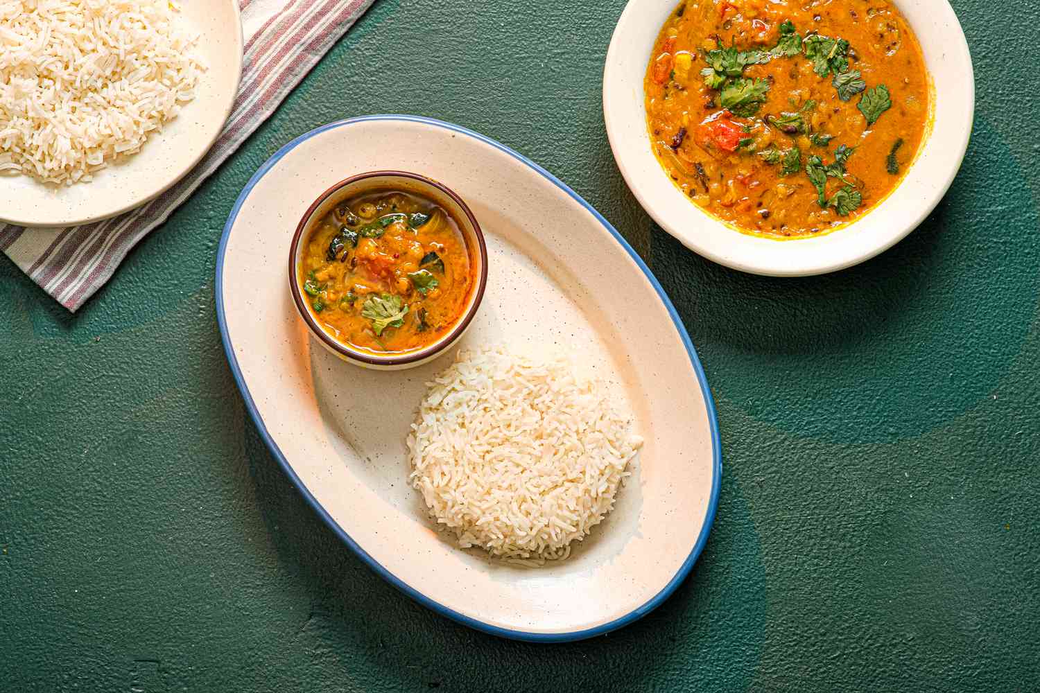Toor Dal in a bowl next to a side of rice. 