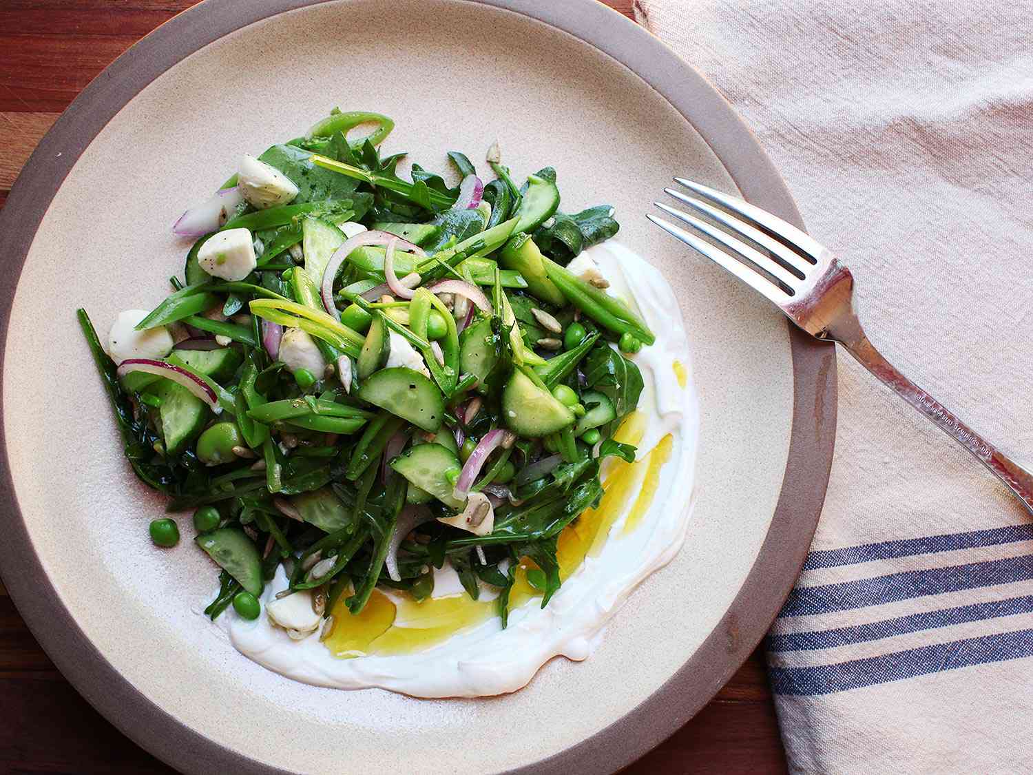 Overhead view of Spring Vegetable and Arugula Salad With Labne and Cucumbers.