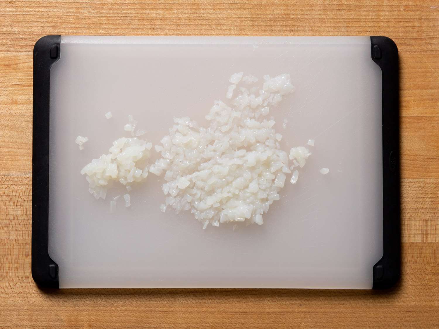 Overhead view of cutting board with minced squid on it. 