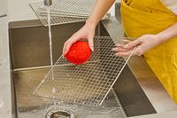 A person washing COSORI Food Dehydrator tray