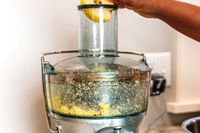 An apple being juiced in a Breville juicer