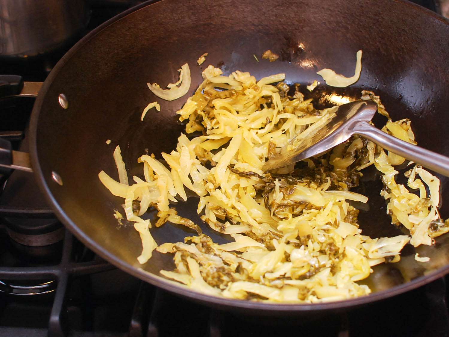 The sliced pickled mustard greens are stir-fried first.