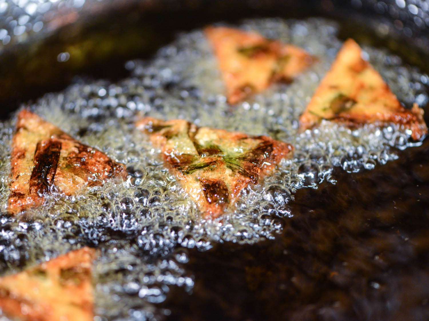 Chive rice cakes frying in oil.