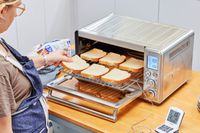 A person placing toast on the Breville the Smart Oven Air Fryer rack