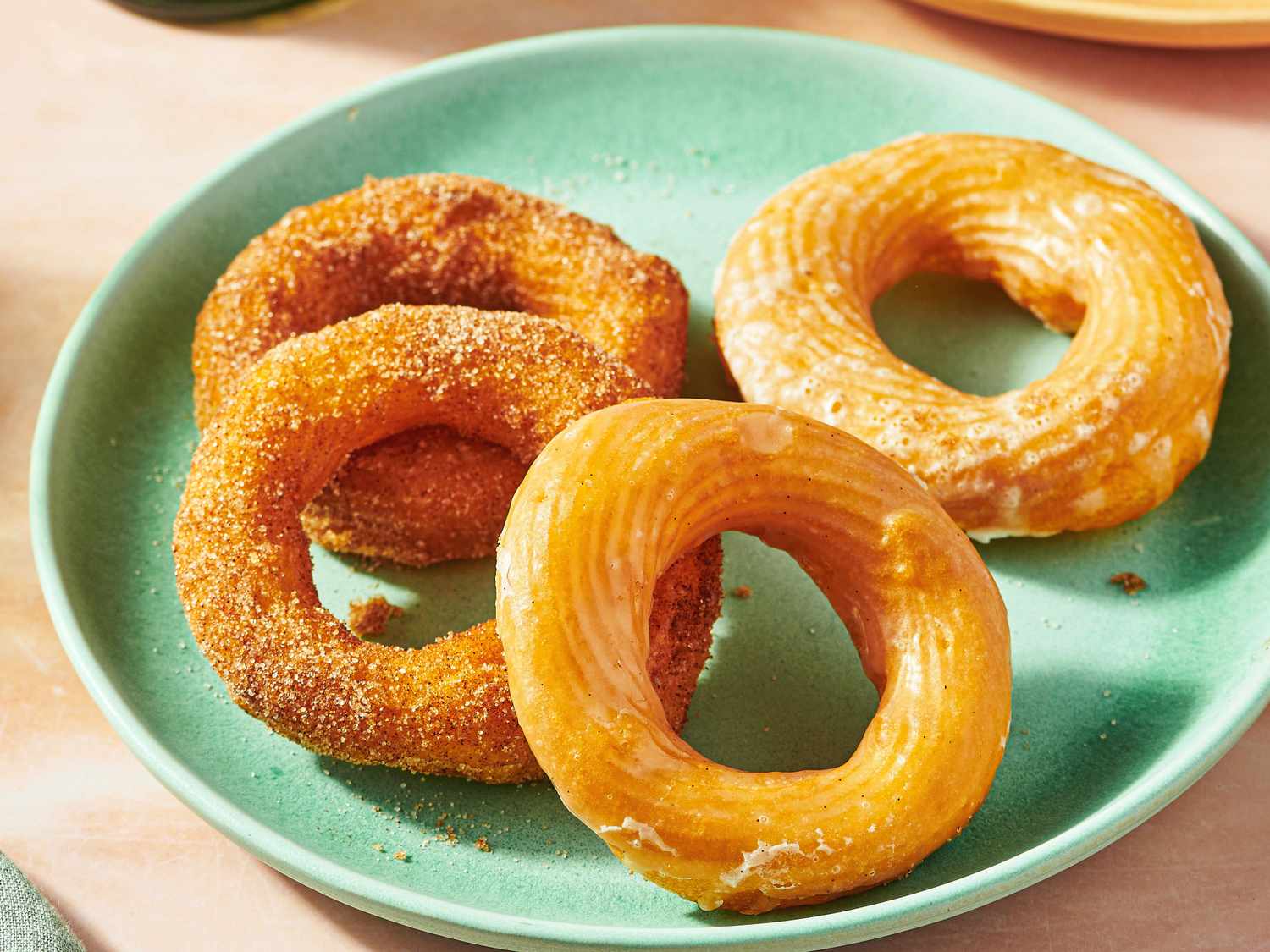 A plate with four cruller doughnuts