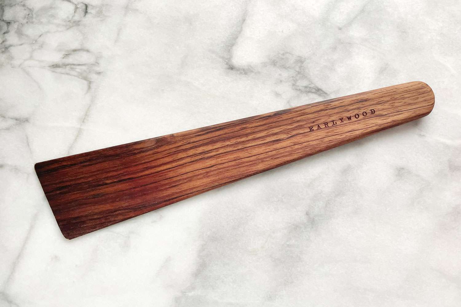 Wooden kitchen spatula on a marble surface