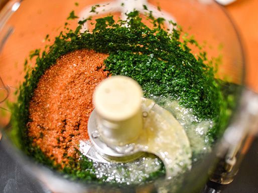 Preserved lemon juice, paprika, cumin, cayenne, and saffron added to a food processor with chopped herbs.