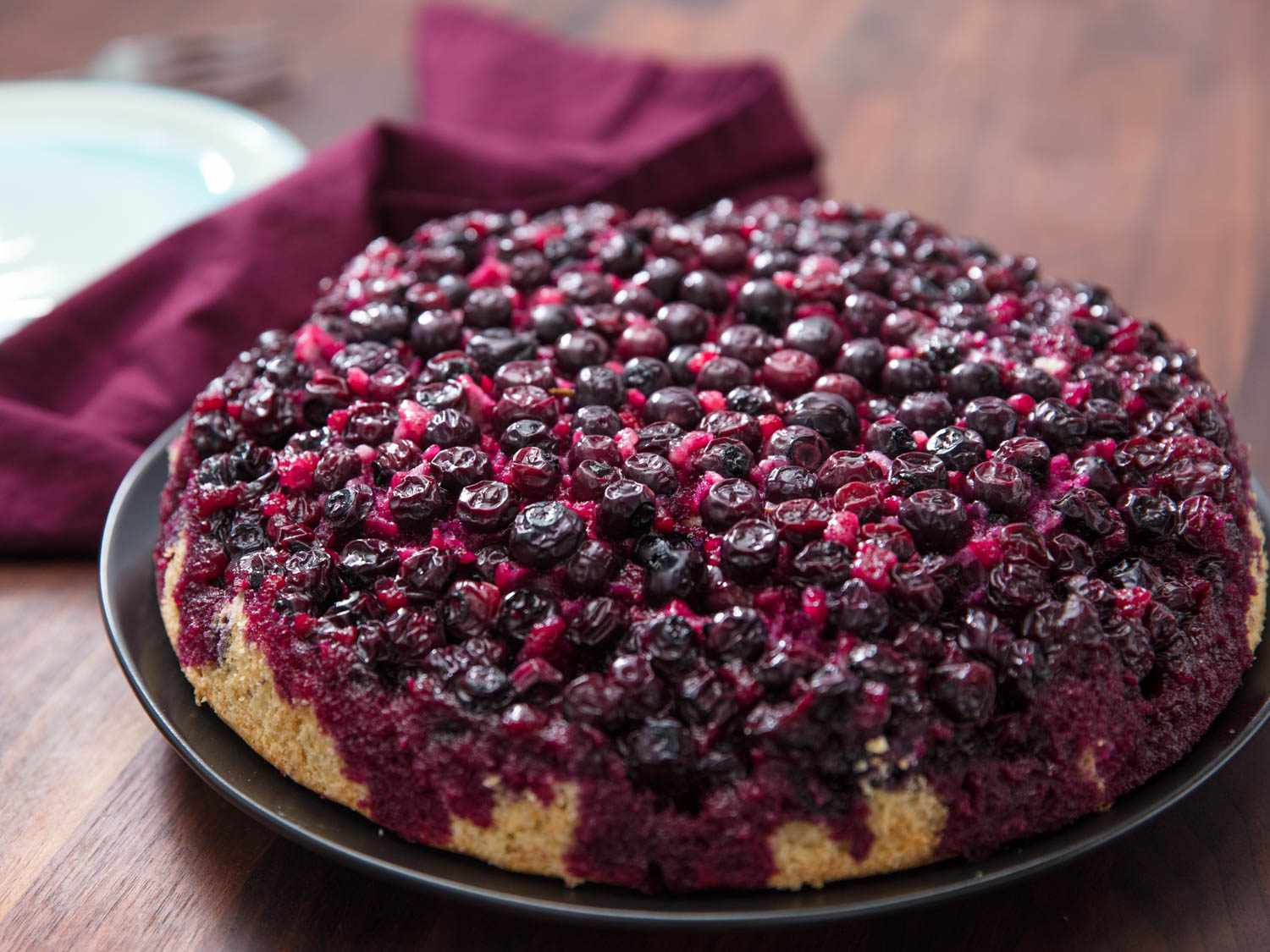 Closeup of a freshly baked upside-down blueberry muffin, ready to serve.