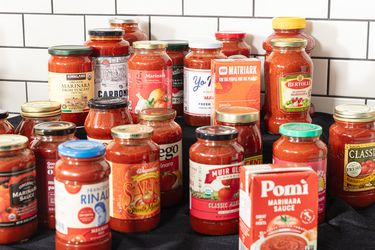 various jars of marinara against white tiles and a black surface 