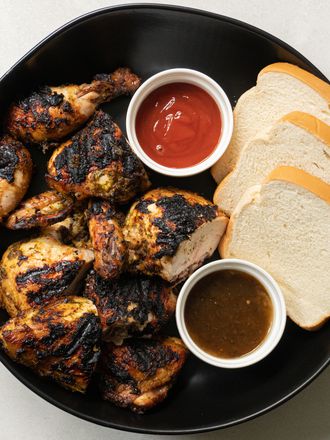 Pan chicken served with white bread and condiments.