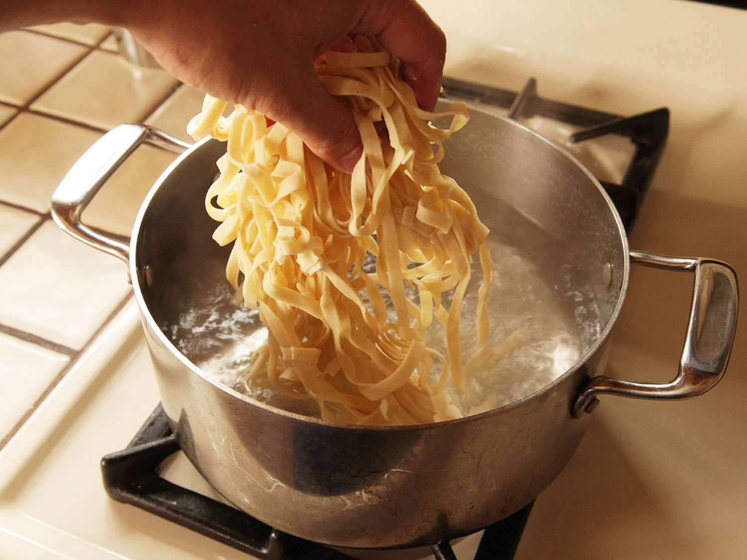 Adding fresh pasta to boiling water.