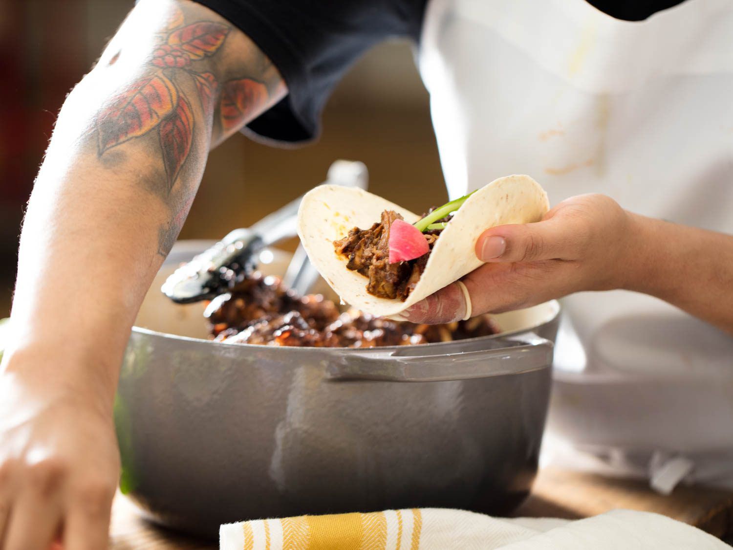 Stuffing tortillas with braised lamb shoulder and radish for tacos