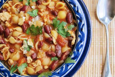 Closeup of Chicken Pasta e Fagiole with Smoked Paprika, served in a white and blue ceramic bowl.
