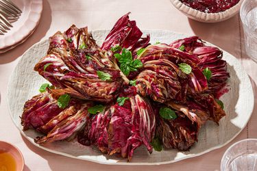 A platter of grilled radicchio garnished with fresh herbs, placed on a set table