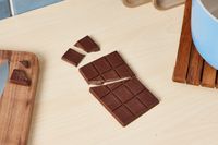 An unwrapped chocolate bar on a kitchen countertop.