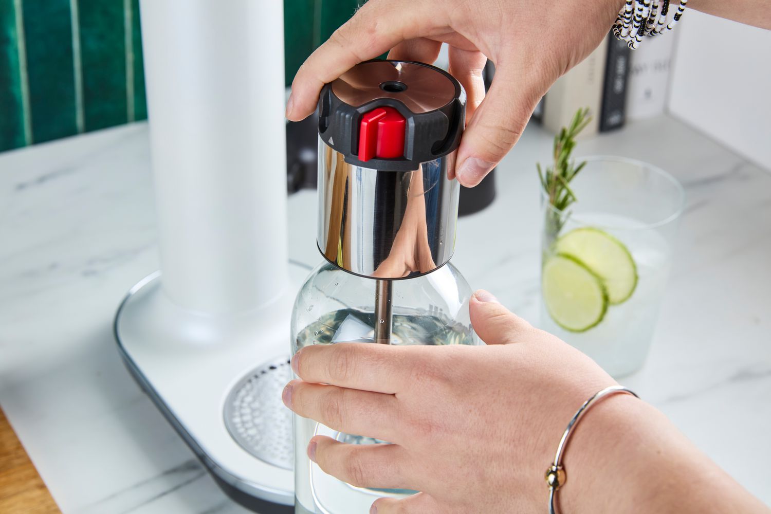 A person attaching the carbonator cap to the Breville soda maker.