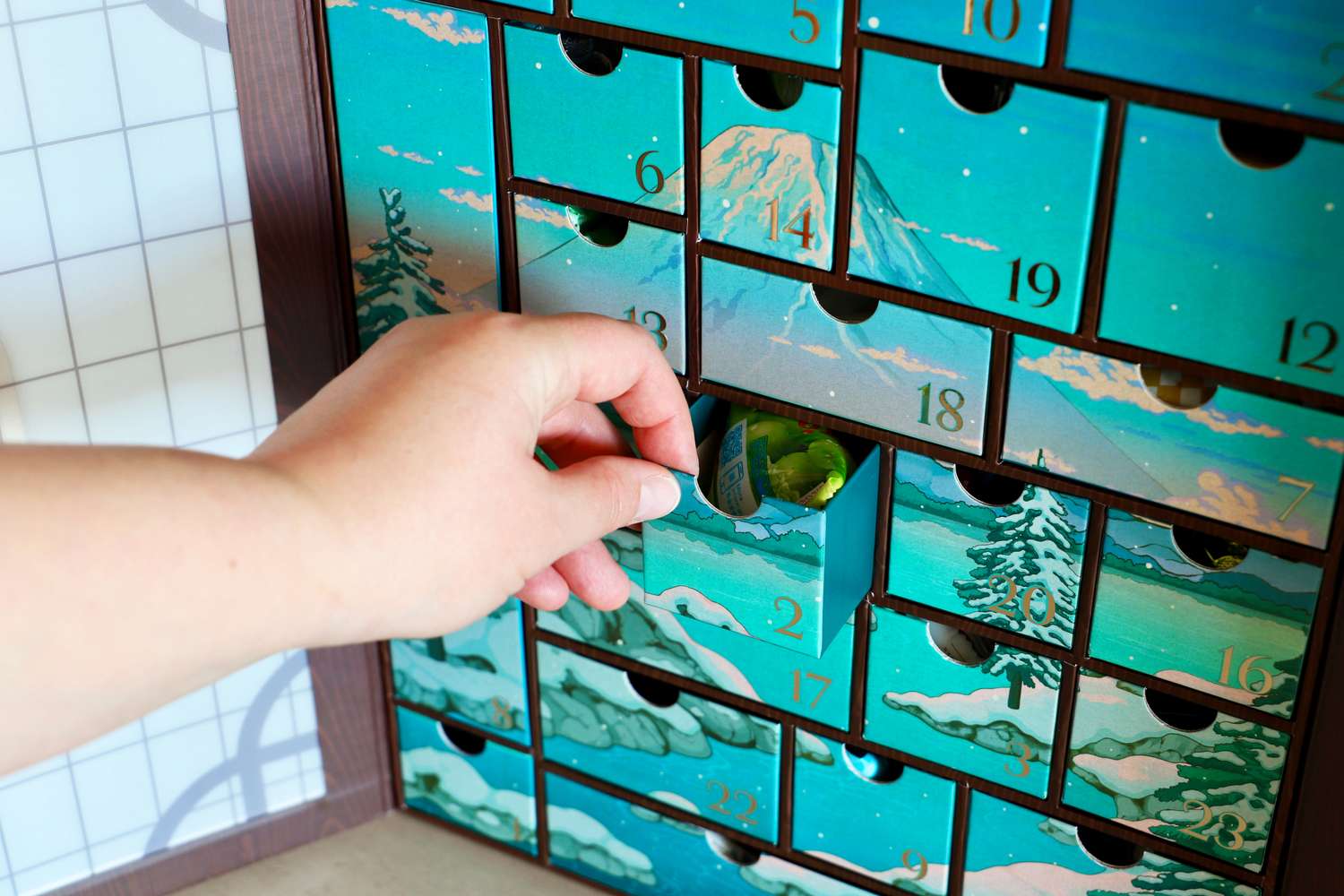 The Bokksu Advent Calendar interior with one drawer being pulled out by a hand