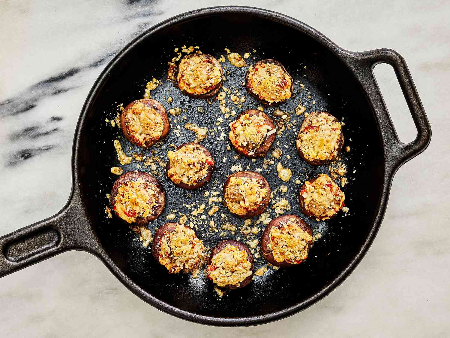 Mushrooms in skillet with browned cheese and panko on top