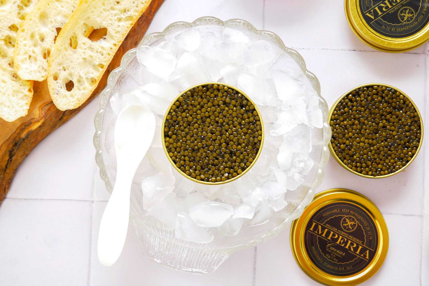 Caviar in tins served over ice with bread slices and a spoon