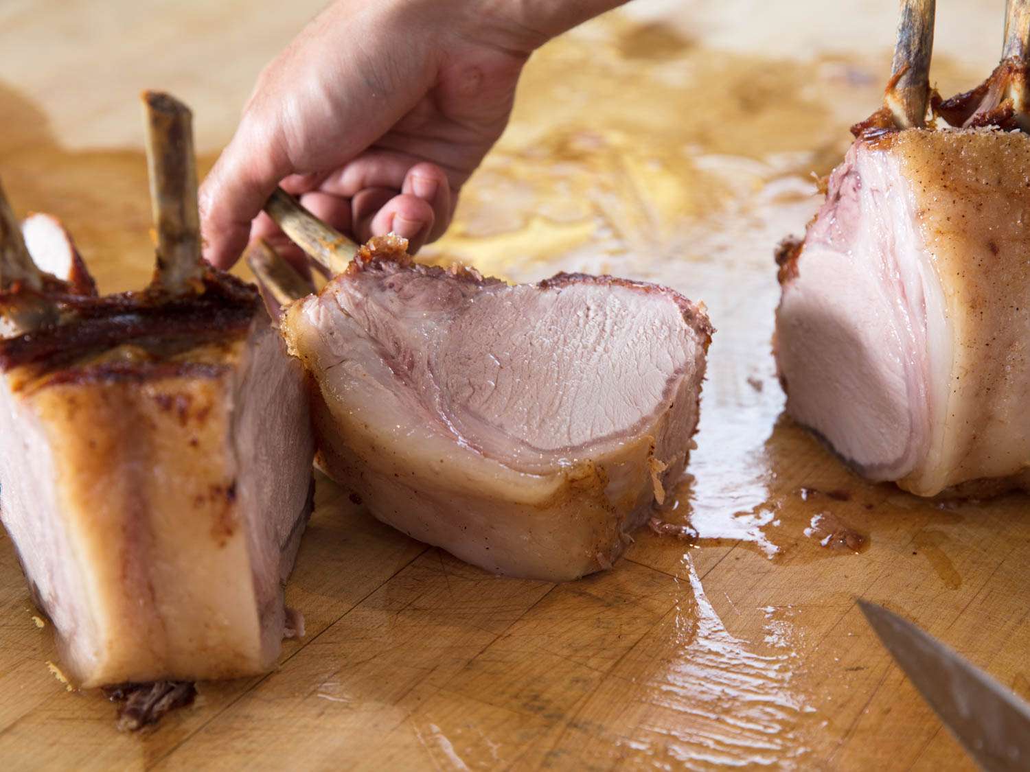 A crown roast being carved into chops for serving.