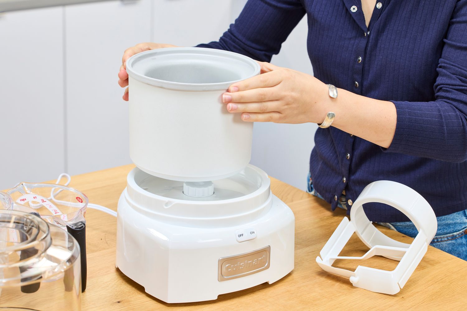 Two hands assembling the Cuisinart 1.5-Quart Ice Cream Maker