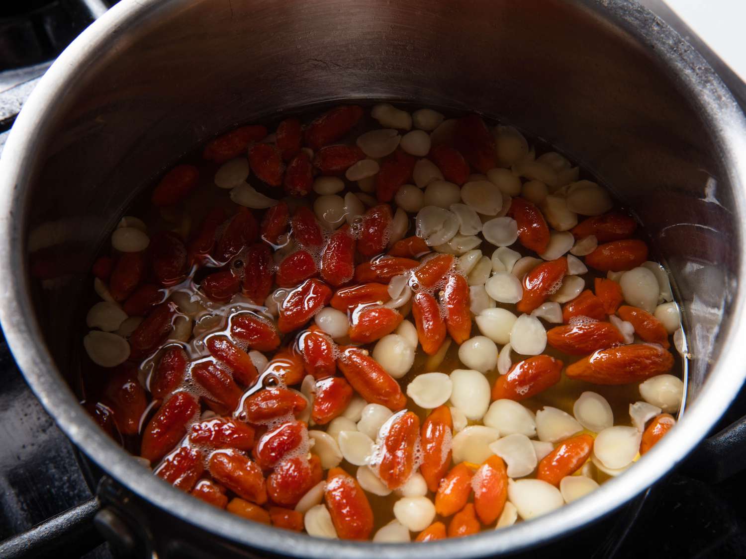Goji berries and Chinese North and South almonds in syrup in saucepan