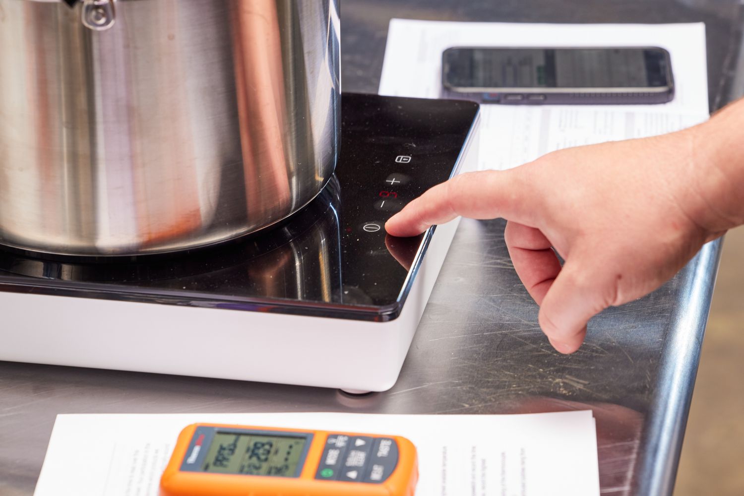 A portable induction burner being programmed.