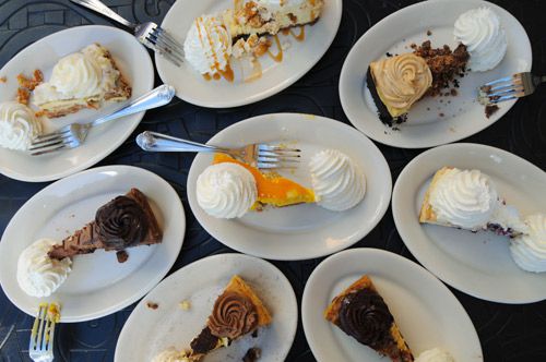 A top down shot of multiple plates holding slices of cheesecake.