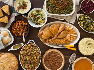 Overhead of a table filled with different Thanksgiving dishes 