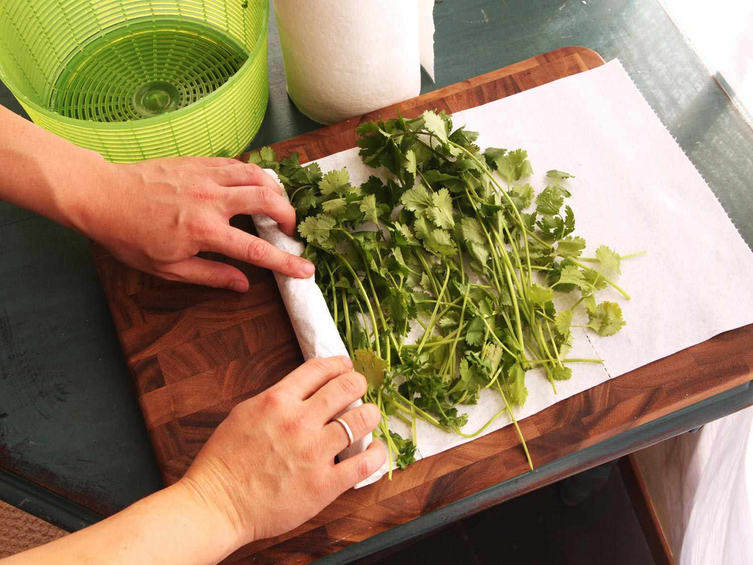 Herbs being rolled up in paper towels. 
