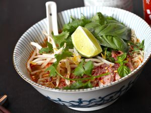 A bowl of Faux Pho, garnished with cilantro, bean sprouts, and a lime wedge.