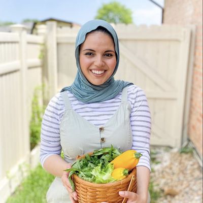 Photo of Serious Eats contributor Heifa Odeh holding a basket of vegetables.