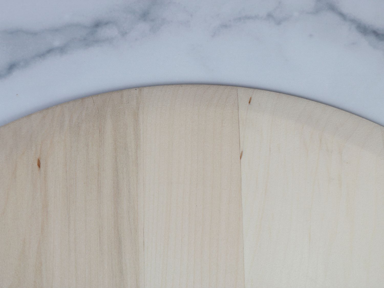 The lip of a wooden pizza peel