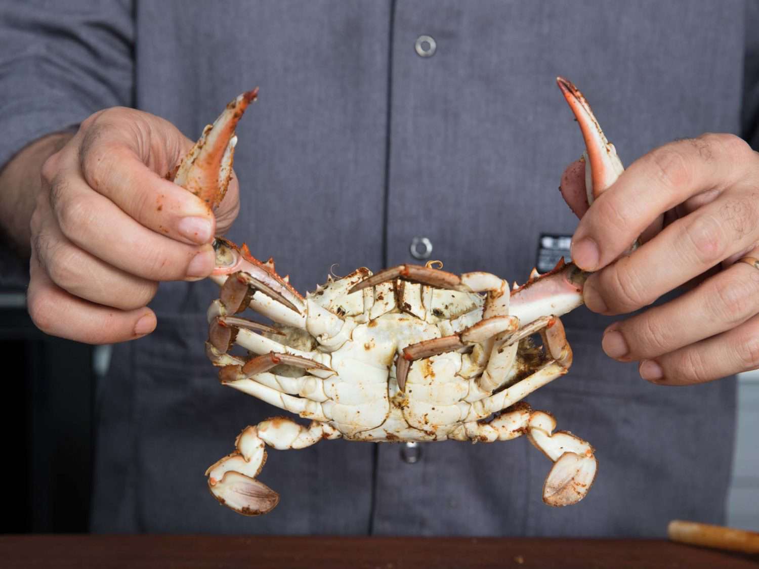 Pulling off the legs of a cooked crab.