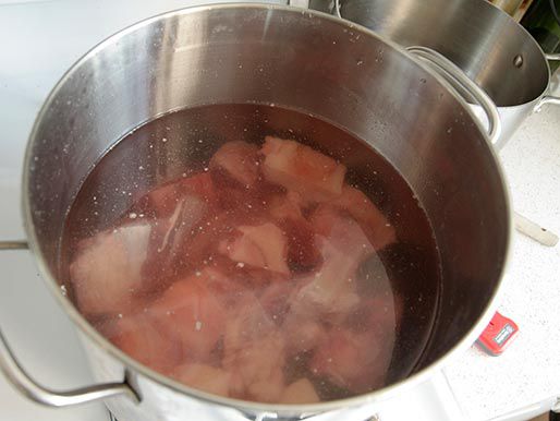 Various pho meat chunks in a pot and covered in water