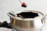 a person removing a strawberry dipped in chocolate