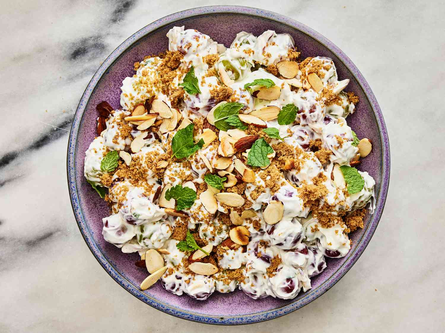 Grape Salad topped with fresh mint on a marble surface 