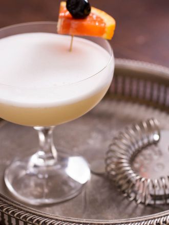 a whiskey sour on a silver tray