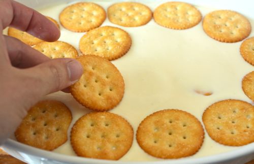Placing buttery round crackers in a key lime pie filling.