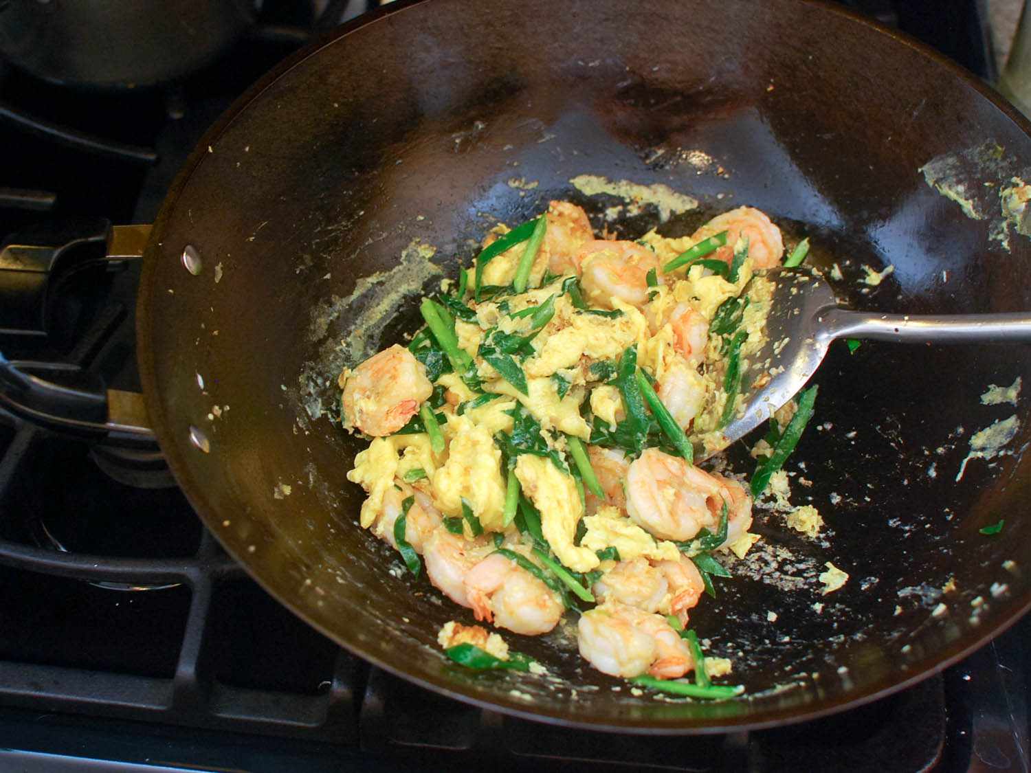 The shrimp and chives are added back to the wok and tossed together with the scrambled egg.