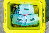 A cooler containing Yeti ice packs and food items arranged inside