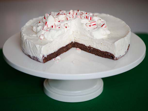 A frozen black bottom peppermint pie, served on a cake stand. Several slices have been consumed.