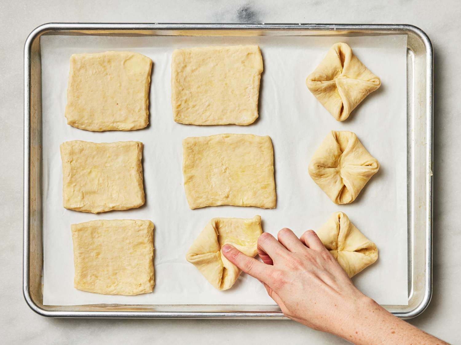 Overhead view of folding dough squares 