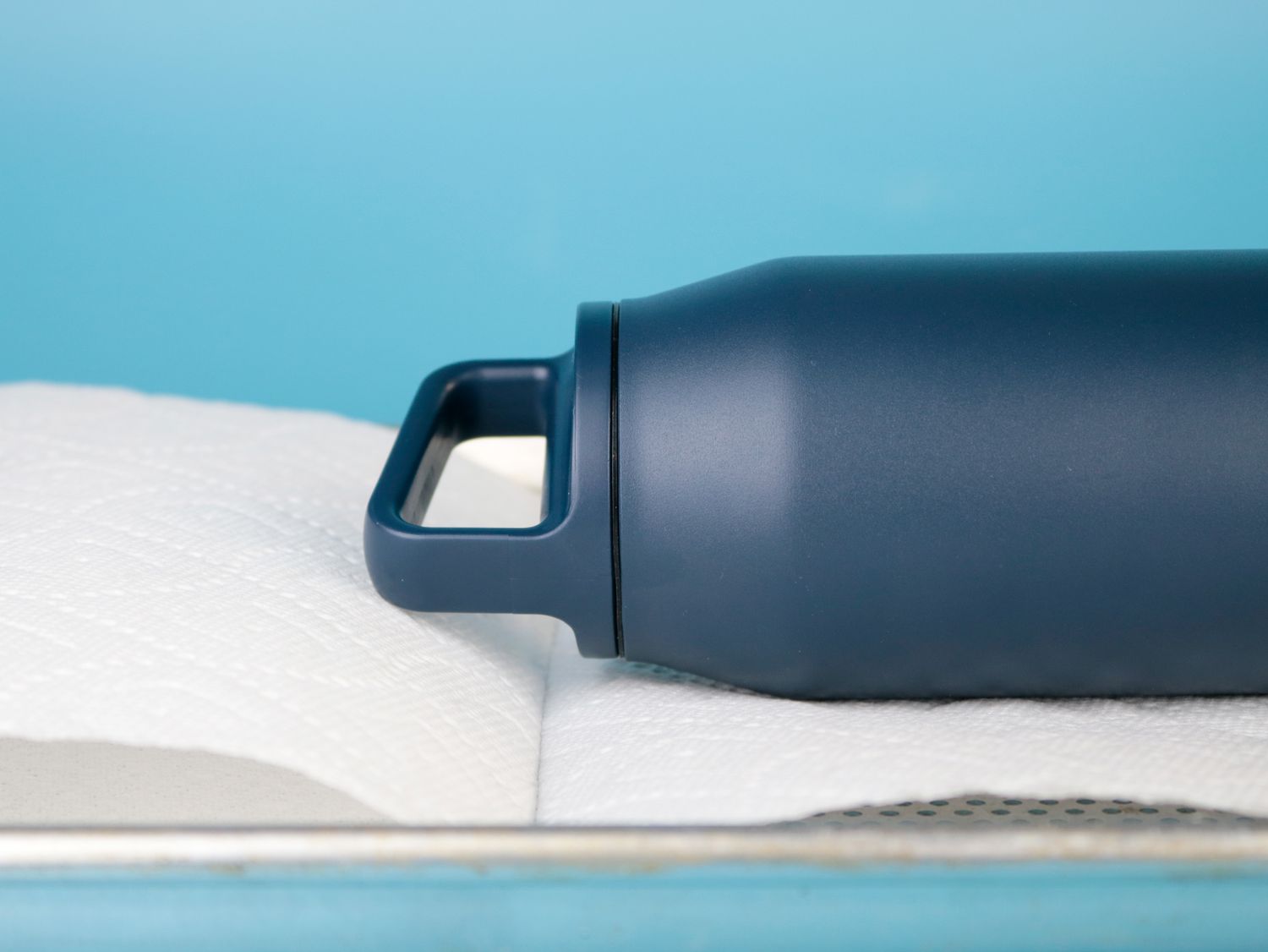 A thermos with a handled lid on its side