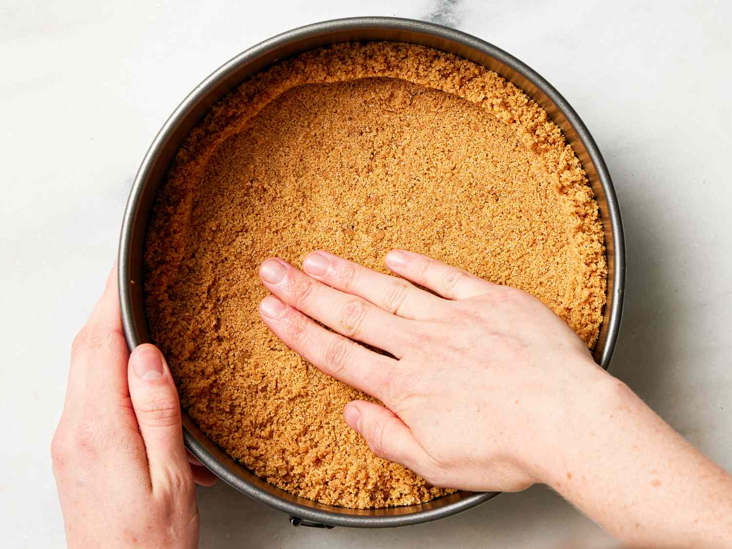 Overhead view of pressing crust into pie pan
