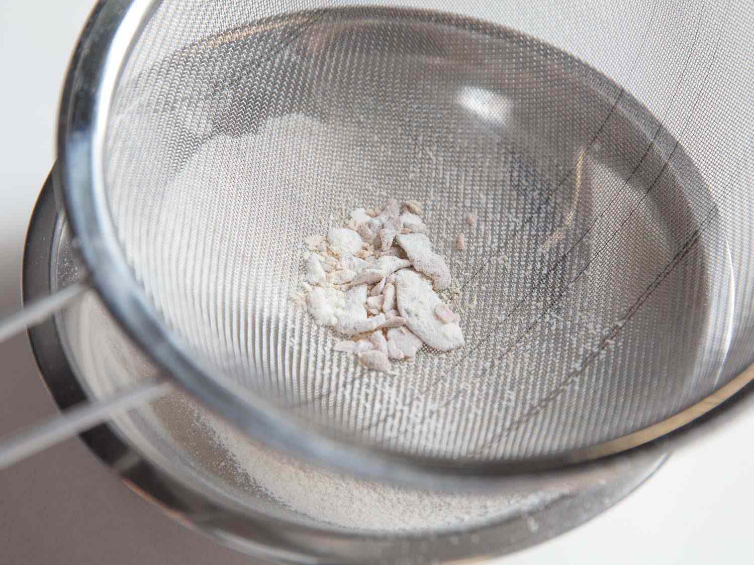 Sifting the used flour to remove clumps.